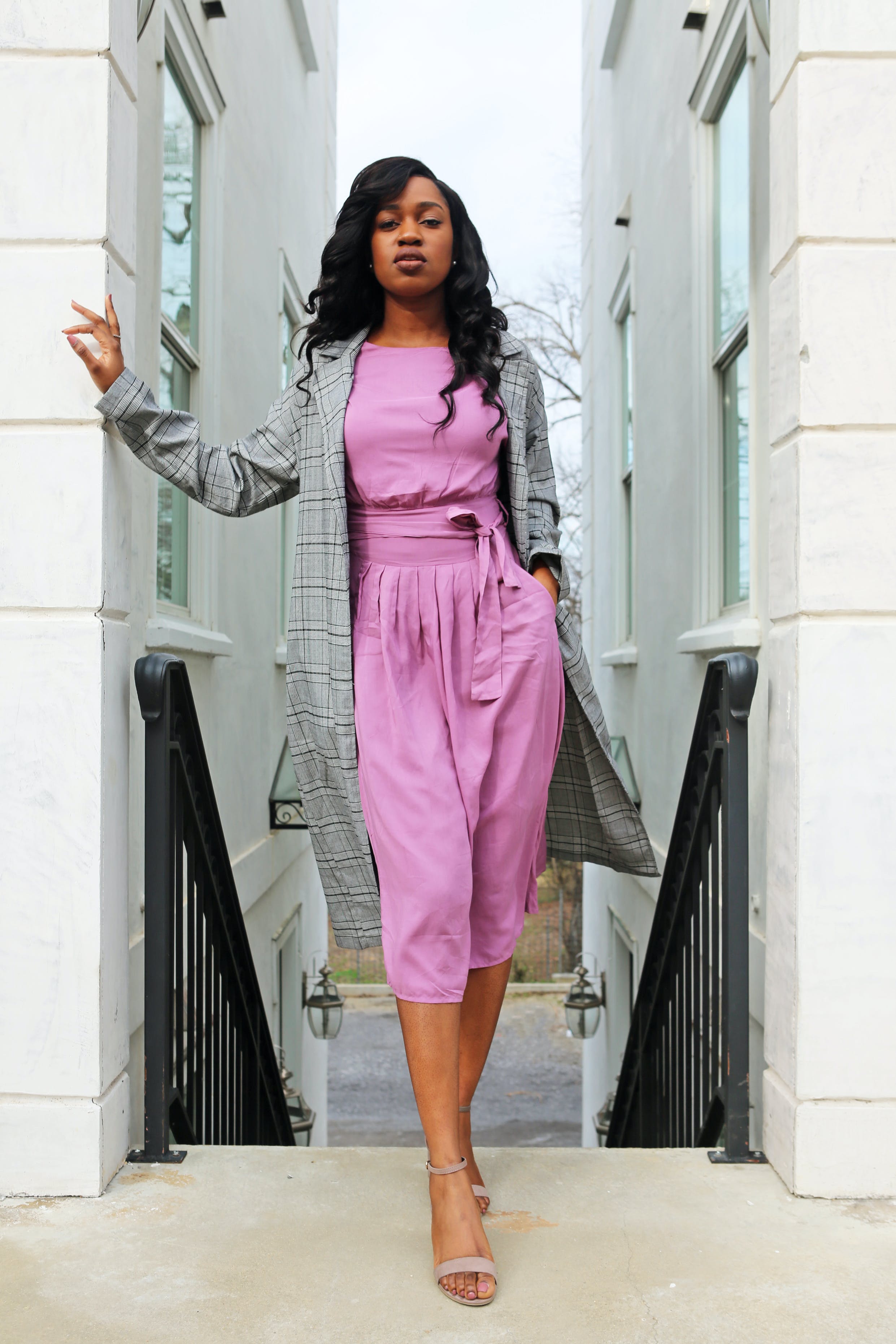 Image of a woman standing wearing a short purple sequin dress.